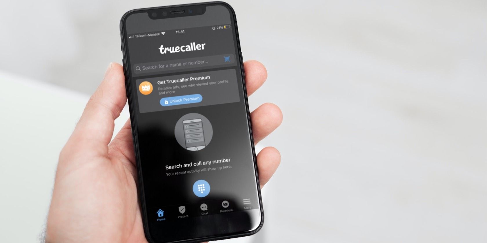 Hands holding iPhone on Truecaller app