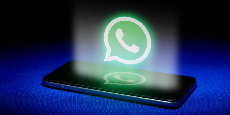 Logo WhatsApp menyala di atas smartphone