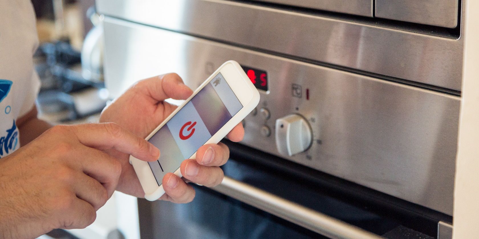 Smart Home: Man Controlling Kitchen With App On His Phone