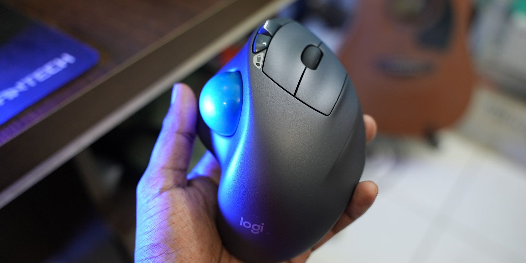 A Logitech M570 Trackball Mouse on a hand with blurred background