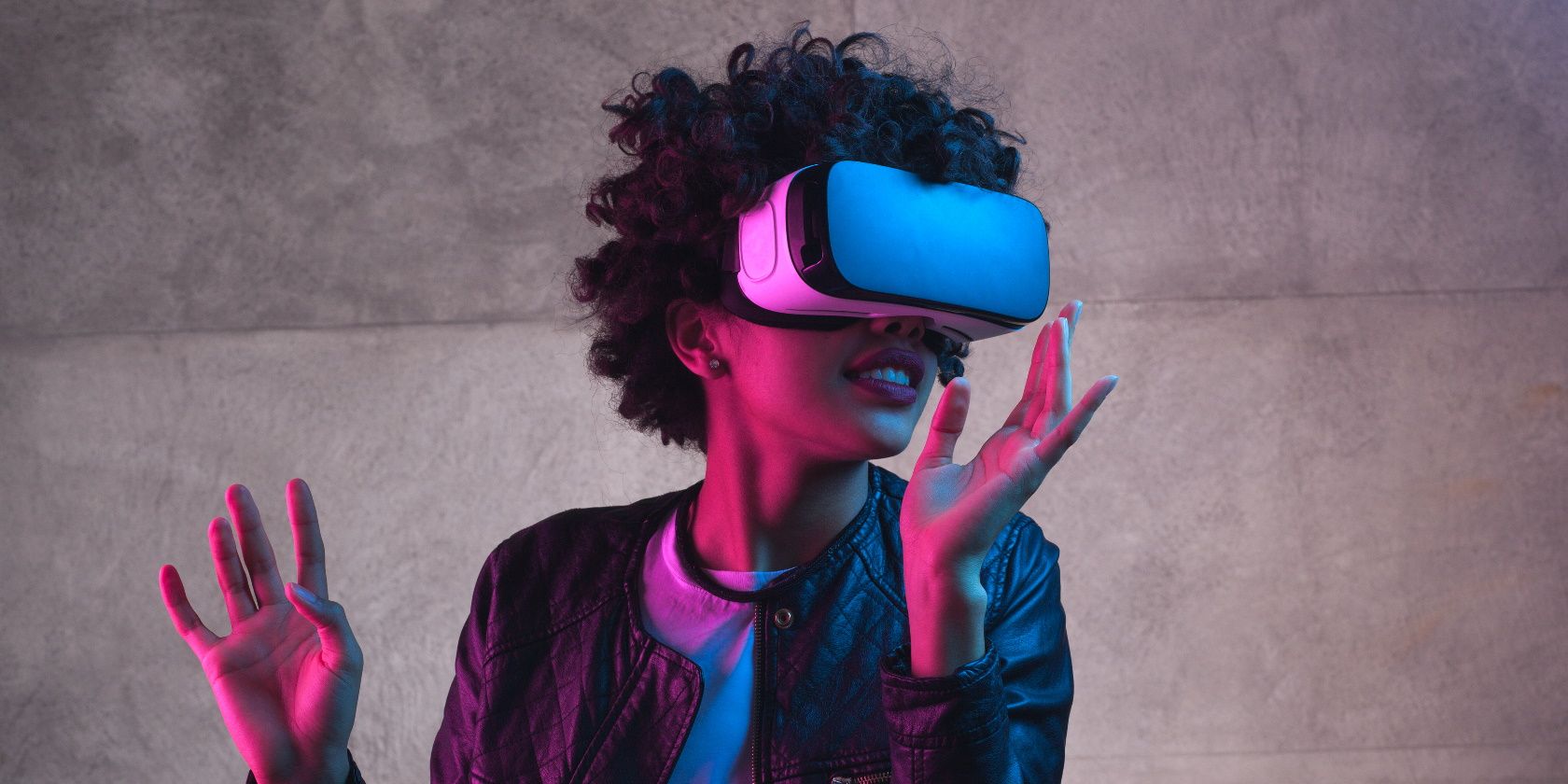 Cheerful girl with hands up wearing the virtual reality goggles