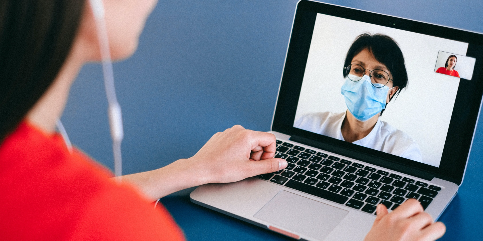 Woman looking at a doctor wearing a mask on a computer video call