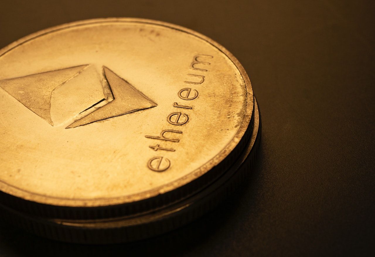 One Ethereum coin on a black surface