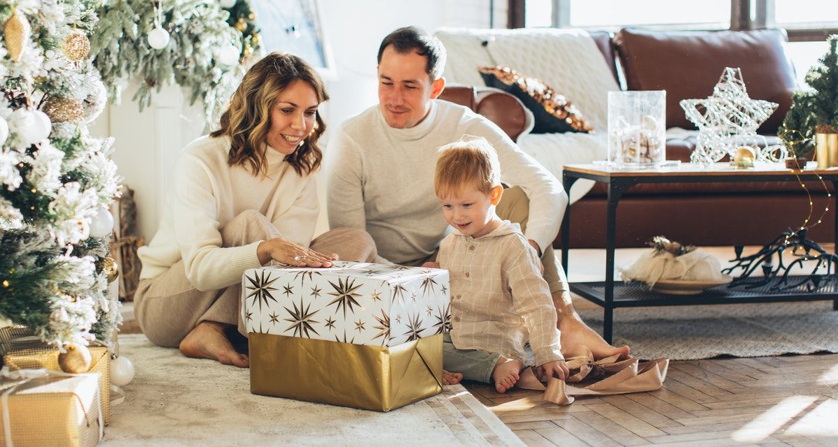 family sitting in front of christmas gift