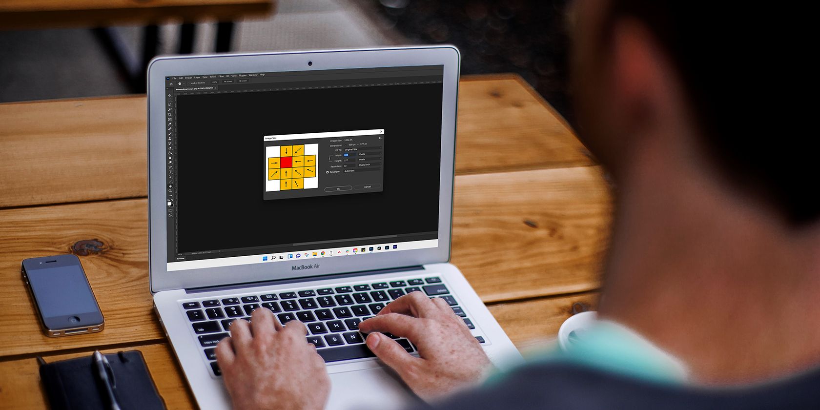 A man resizing an image in Photoshop.