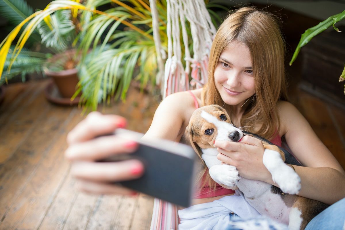 girl taking selfie with dog