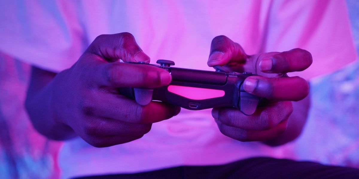 A person holding a purple PS4 controller