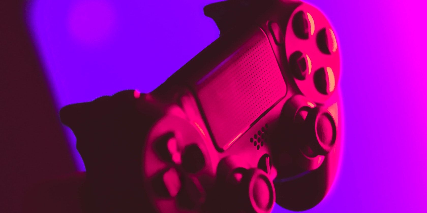 a PS4 controller in a purple and red light