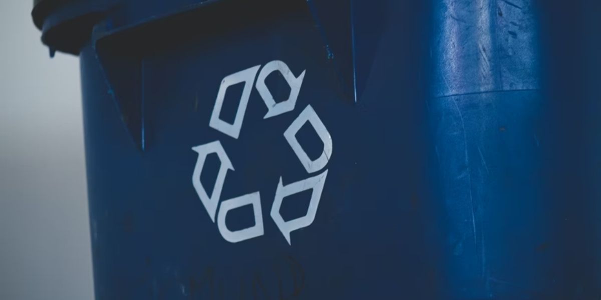 white recycling symbol on blue colored recycling bin 
