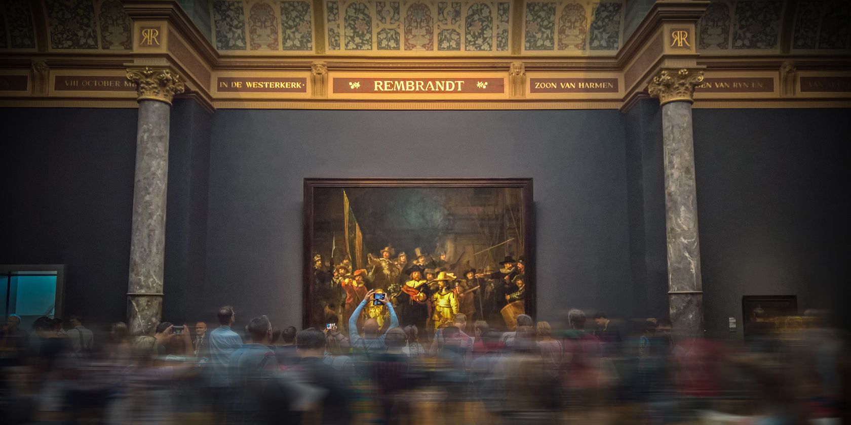 A Rembrandt painting on display in a crowded museum.