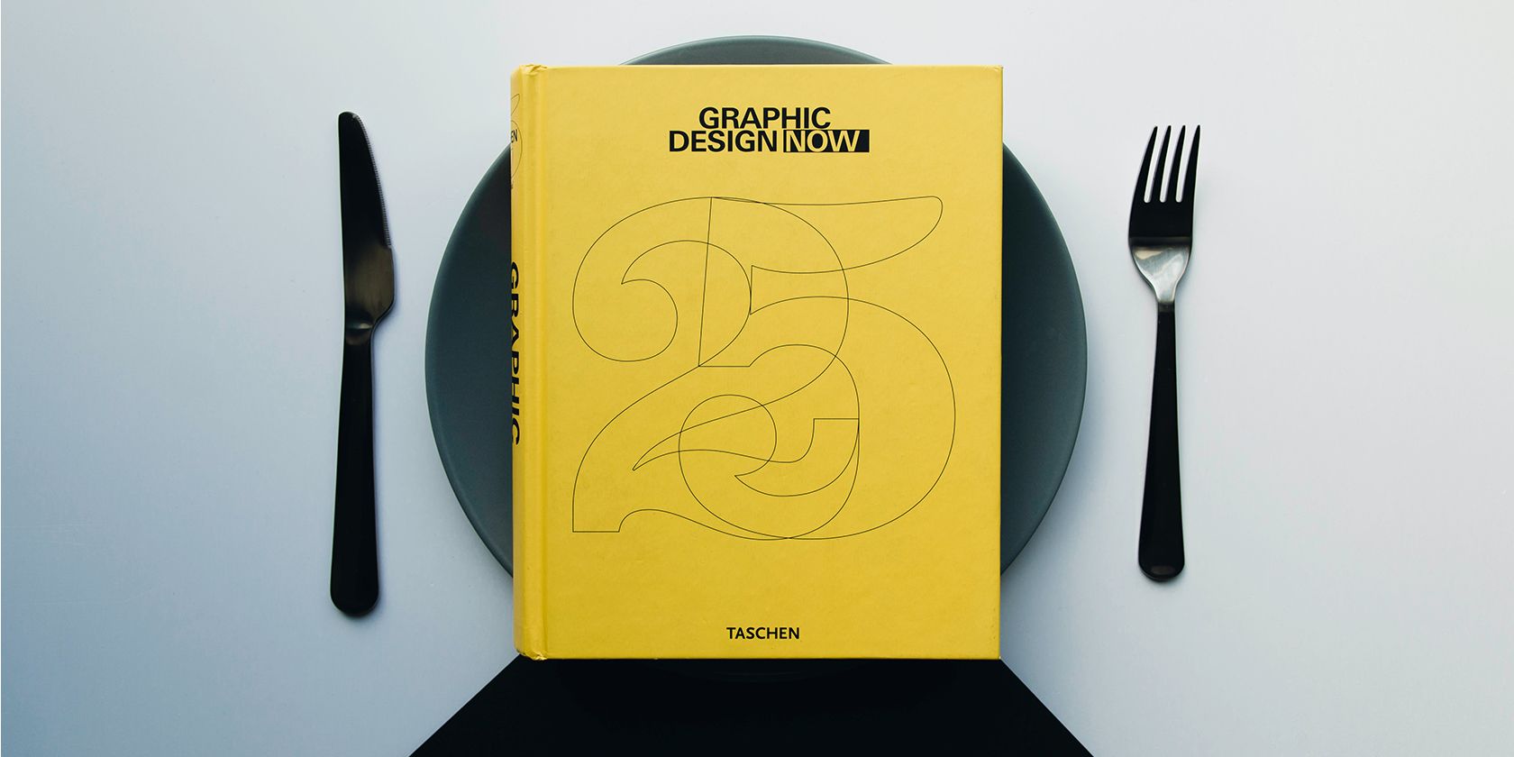 A book on graphic design on a black plate.