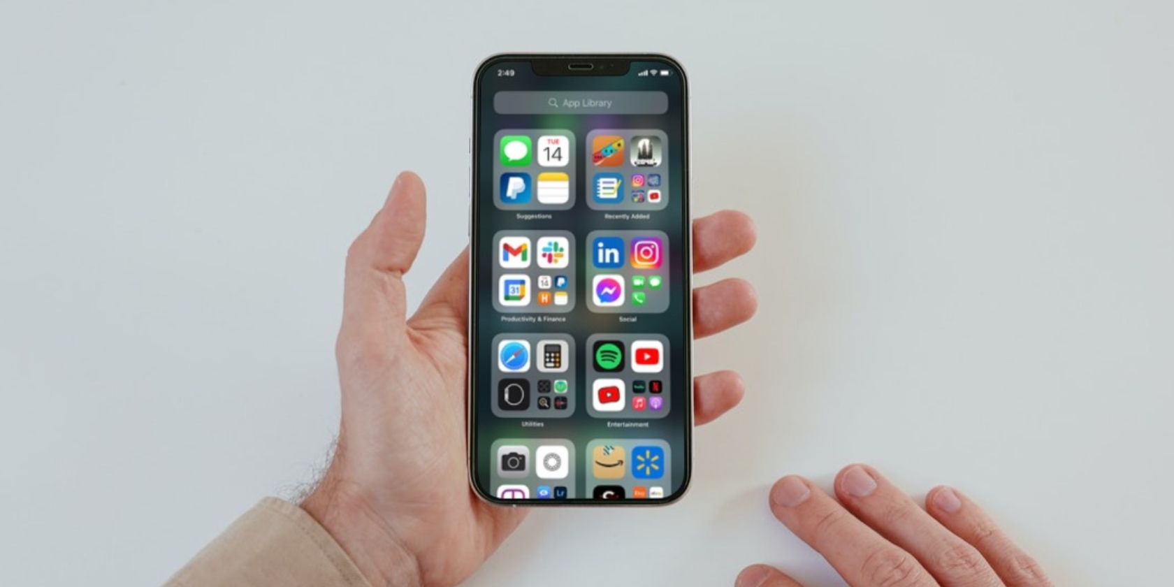 Image shows an iPhone with the App library on the screen