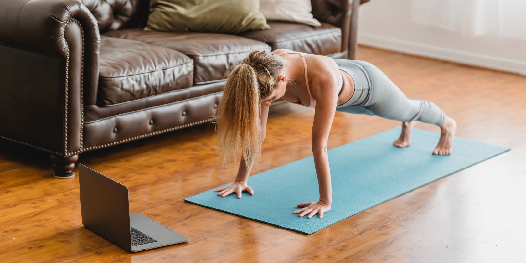 woman working out at home using laptop