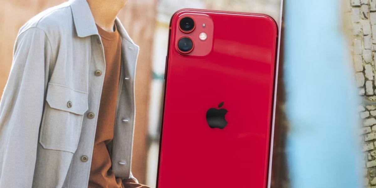 red iphone 11 next to magazine photo of man wearing light blue button up shirt