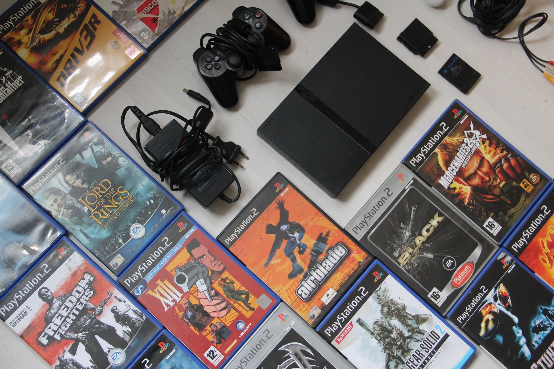 Playstation 2 Slim Surrounded by PS2 Games and Controller