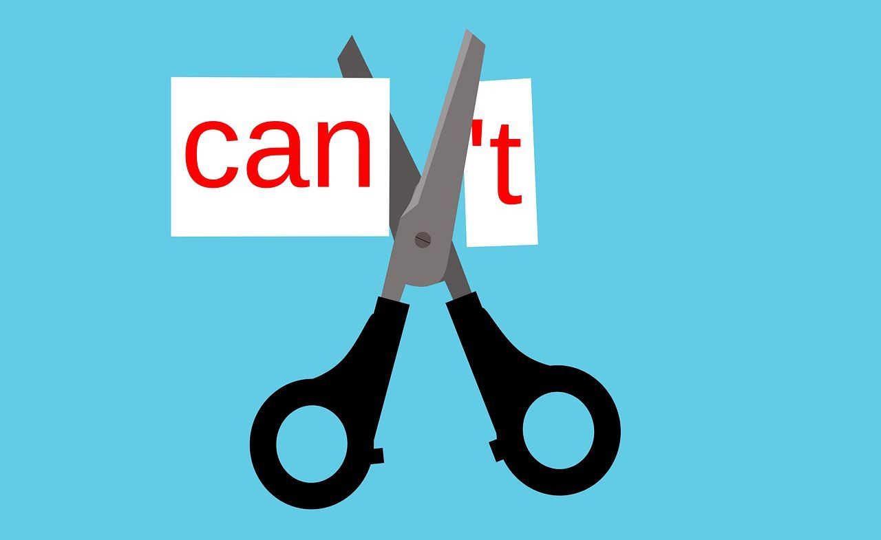 Illustration of Scissors Cutting Paper With "Can't", to Show "Can"