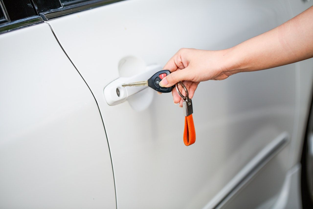a person holding a key near a car door