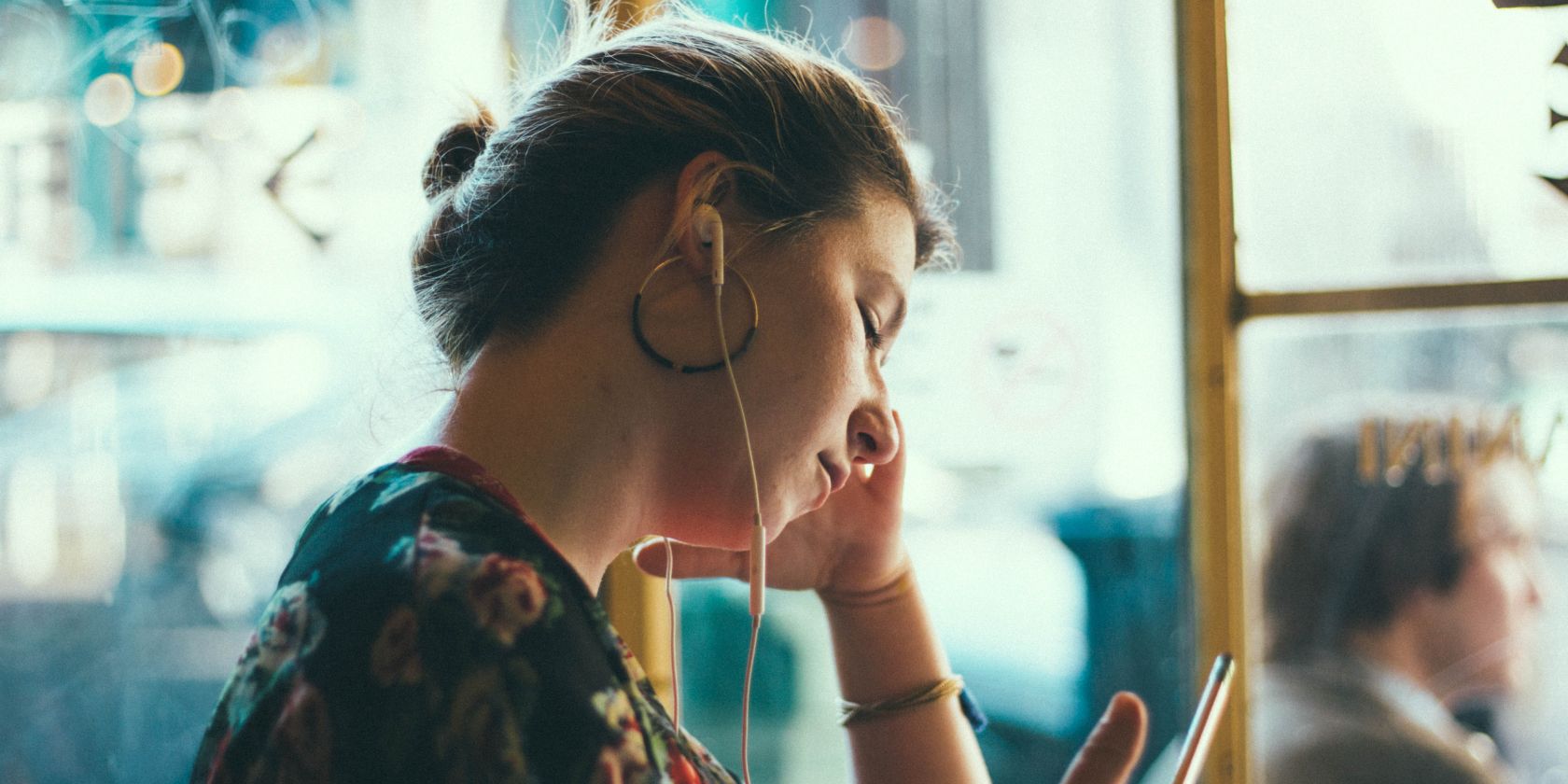 Femme portant des écouteurs et se concentrant sur quelque chose devant elle