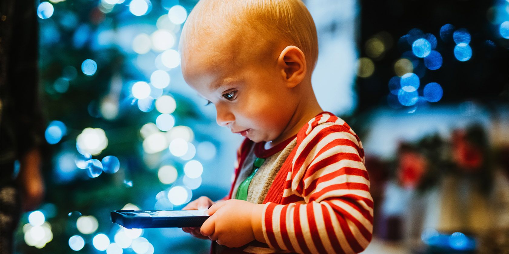 child looking at phone during christmas