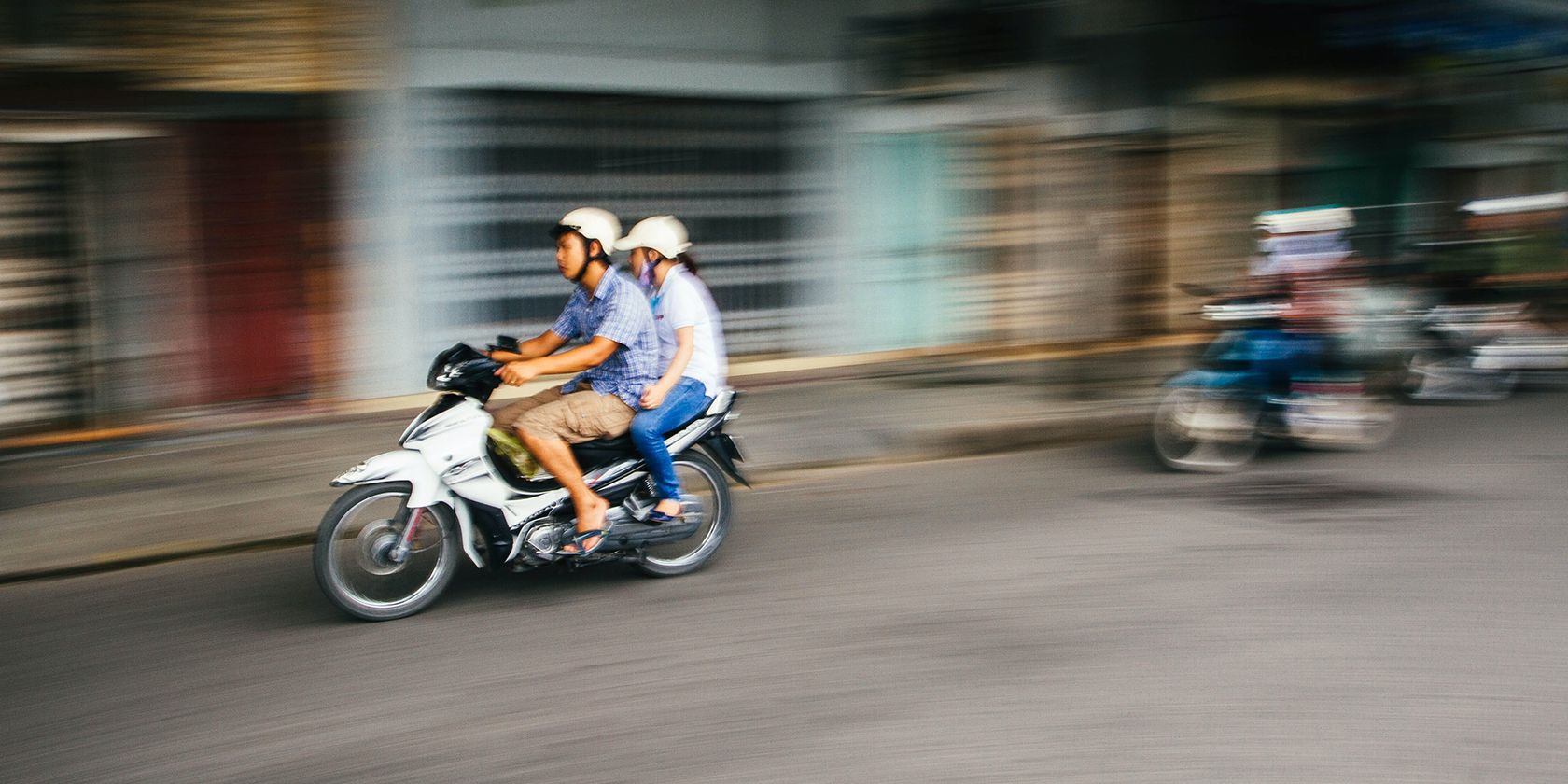 two riders sitting on a fast motorcycle