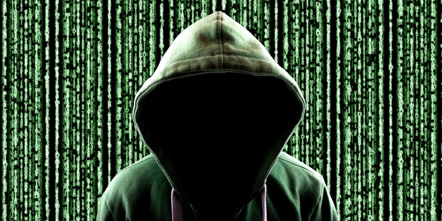hooded hacker in front of a giant screen