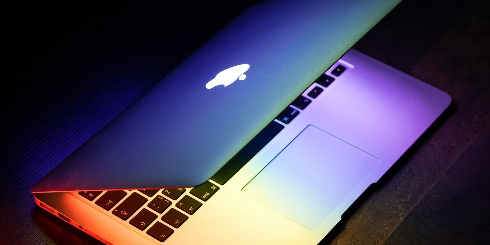 macbook laptop on dark background with bright wallpaper