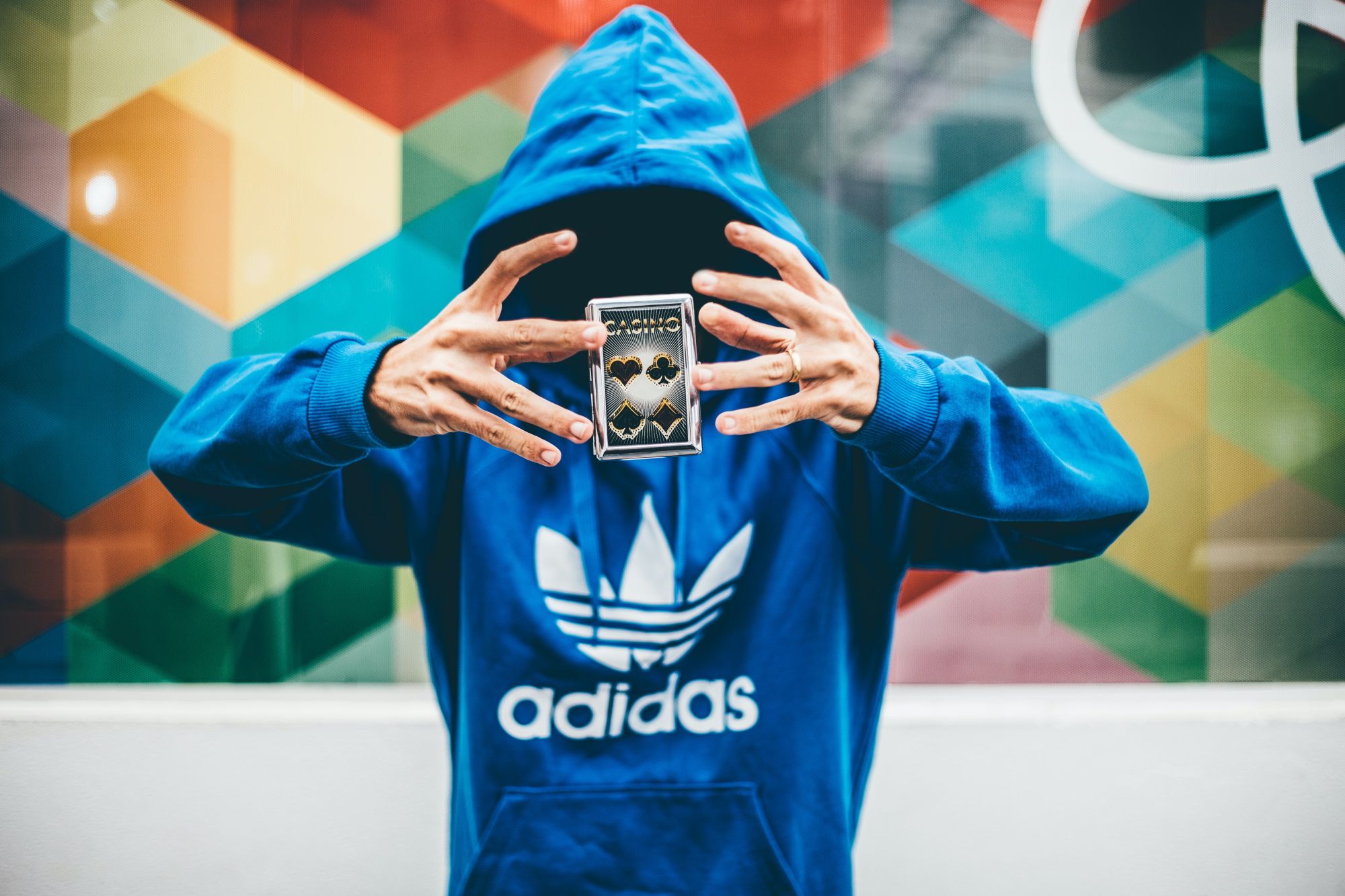 man with adidas hoodie and card