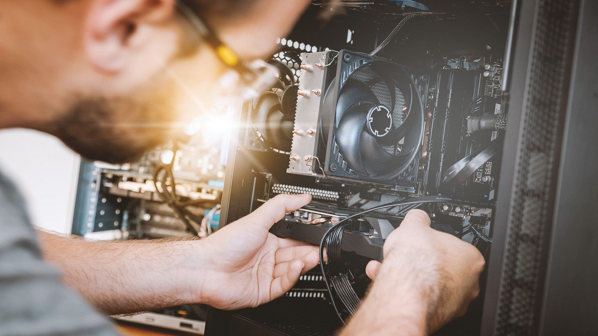 man working on an open desktop computer