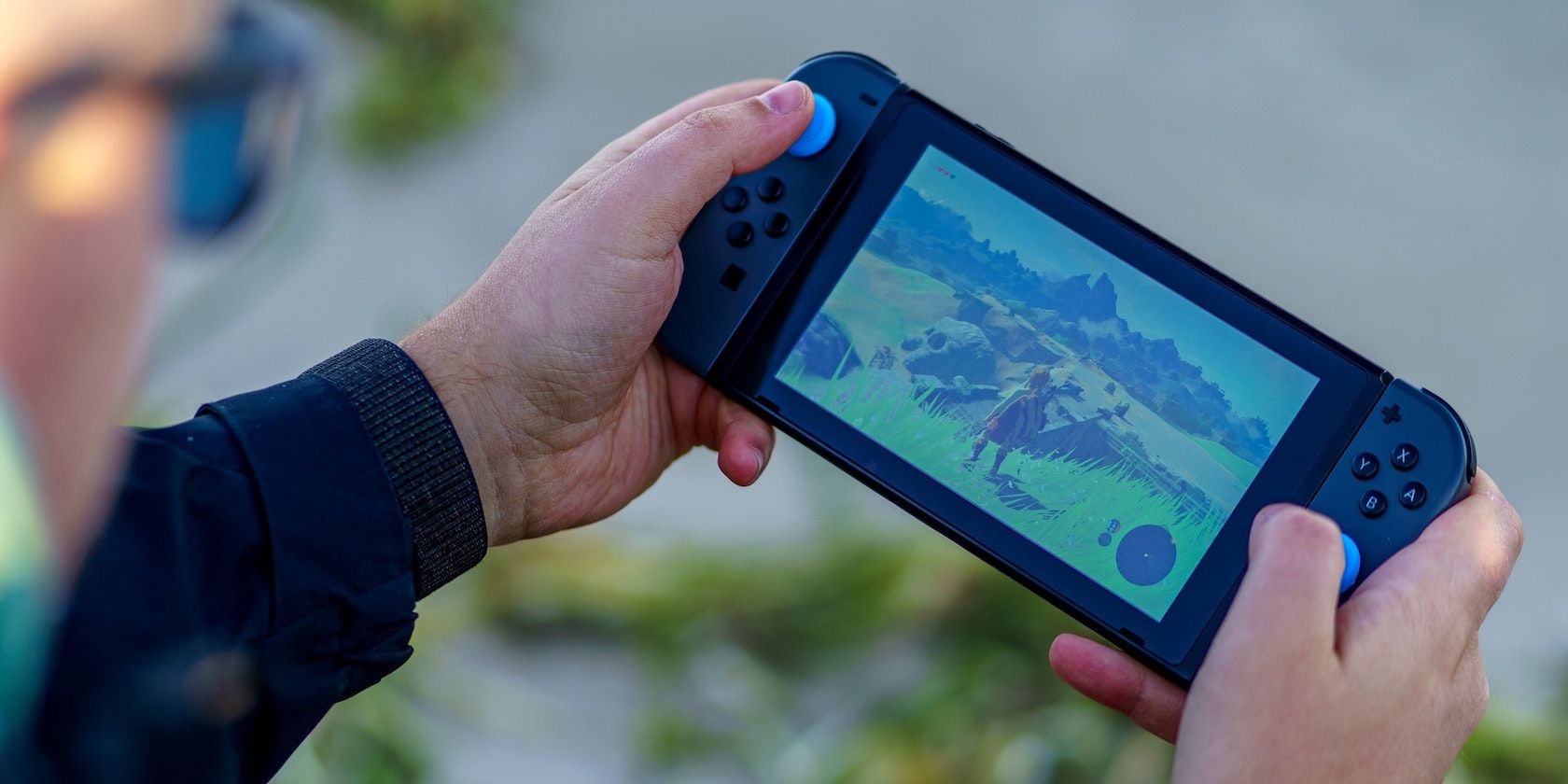 person playing Breath of the Wild on the Nintendo Switch in handheld mode