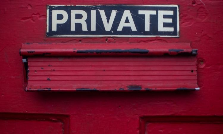 privacy sign above mail slot on red door