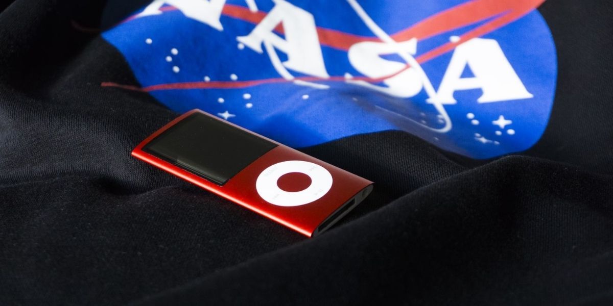red ipod nano on black fabric with nasa logo