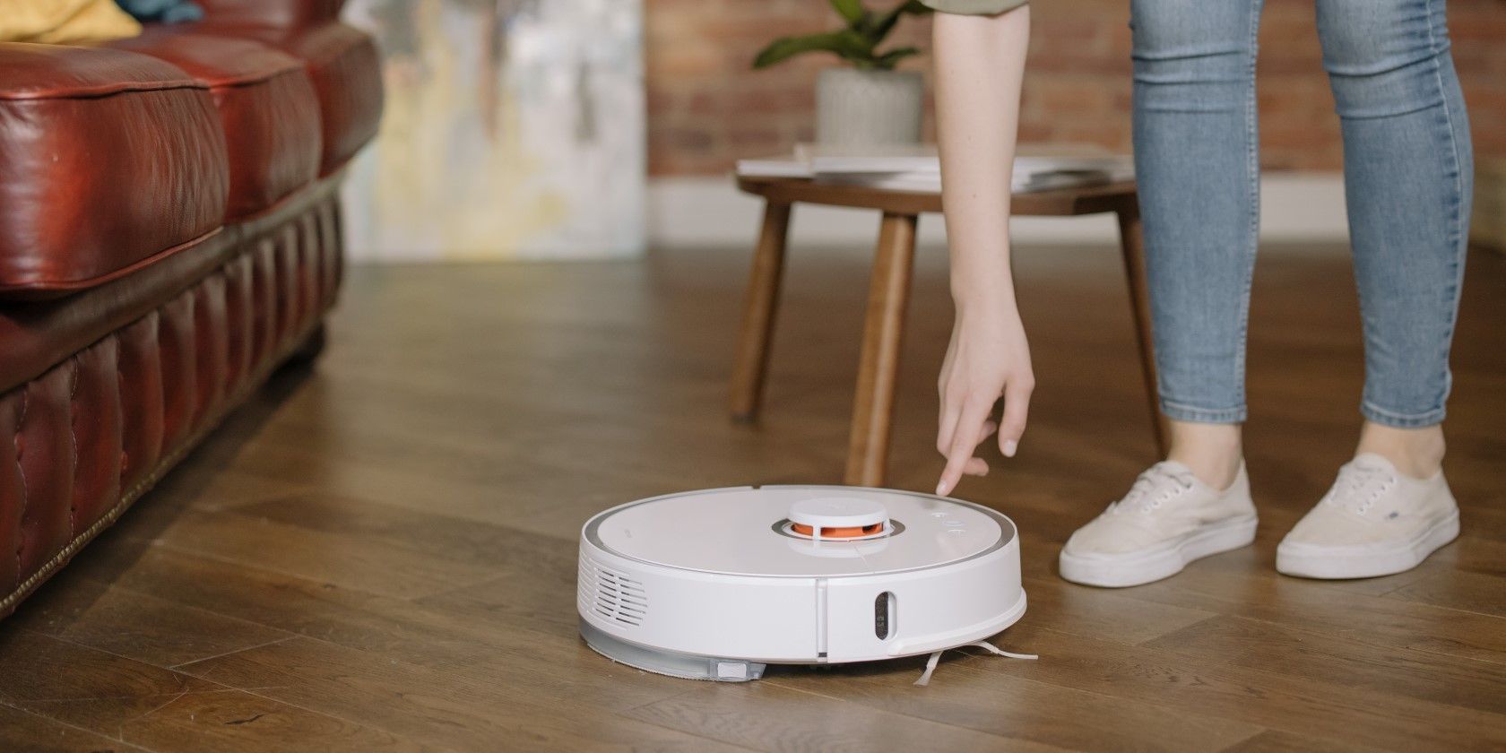 person turning on robot vacuum