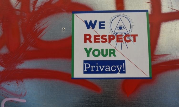 "we respect your privacy" sign on graffitied wall