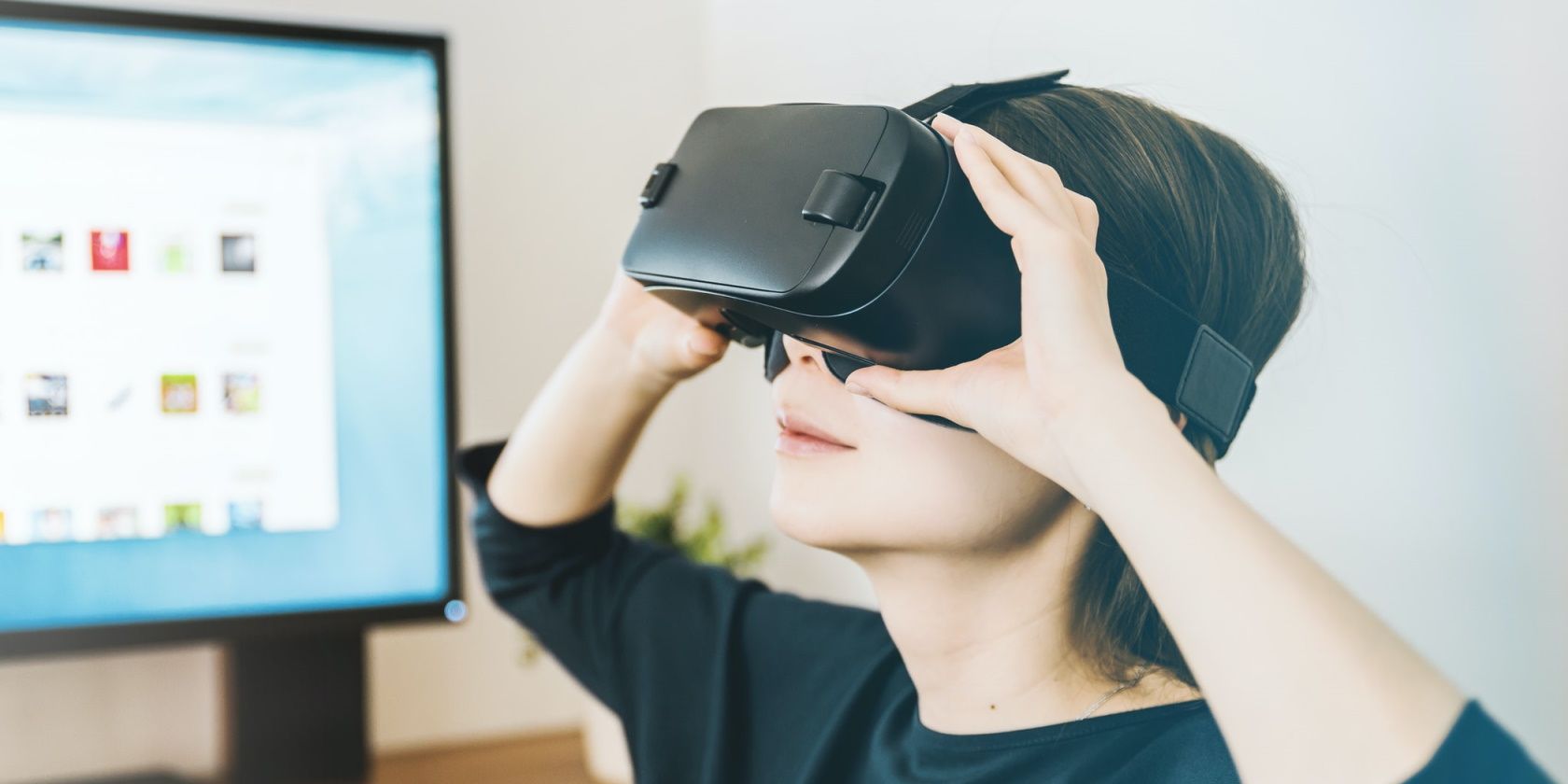 a woman wearing a vr headset with a monitor behind her
