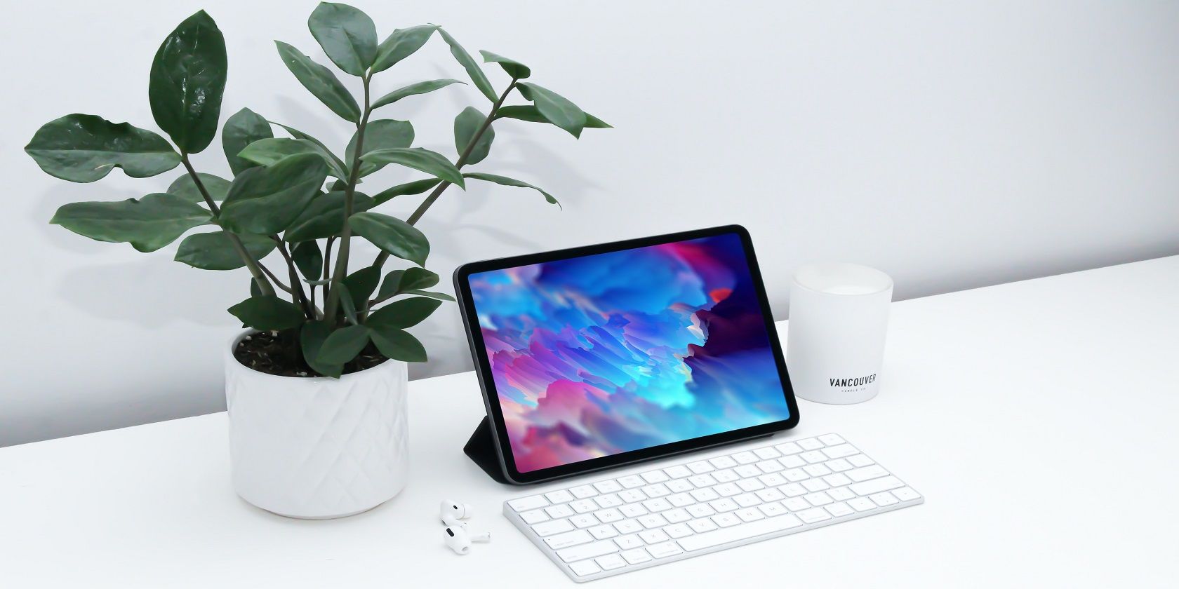 An iPad with a keyboard, beside an indoor plant - unsplash.co