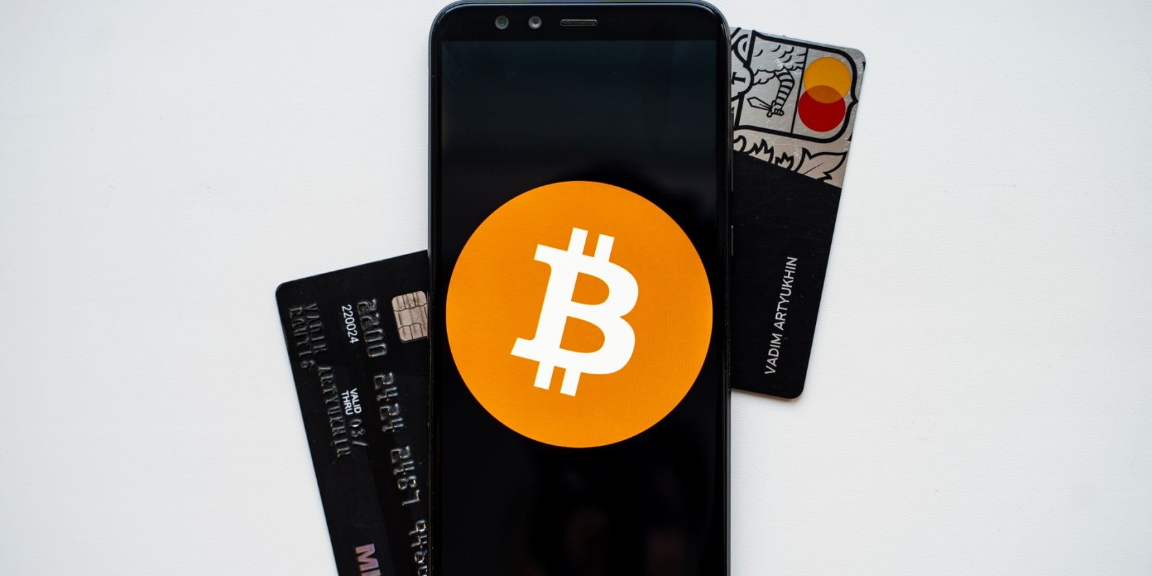 A mobile phone with a Bitcoin symbol superimposed on top