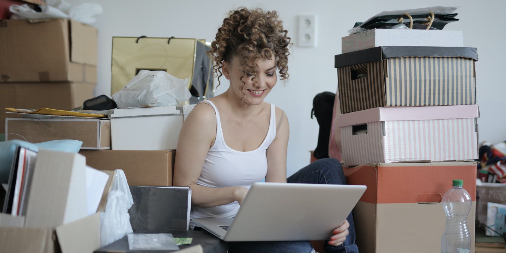 woman sitting in clutter using laptop