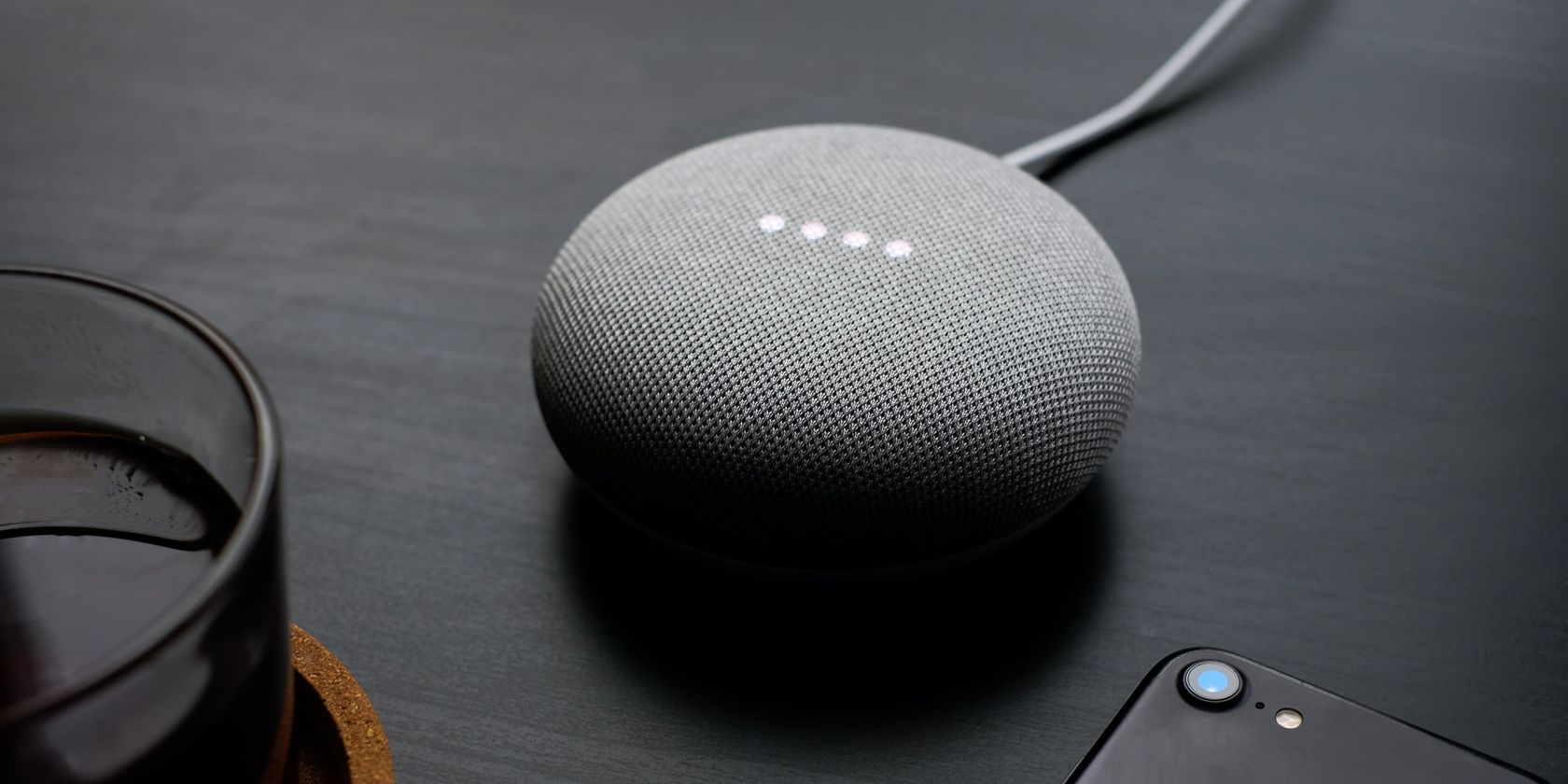 Google Nest Mini smart speaker sitting on a desktop.