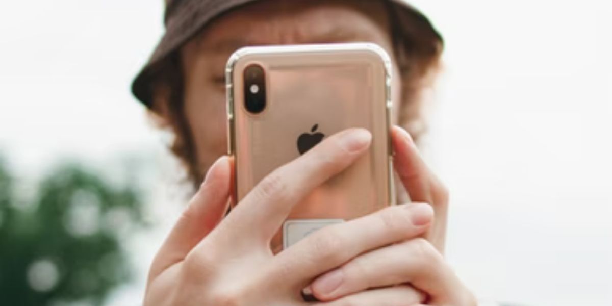 man holding gold iphone xs 