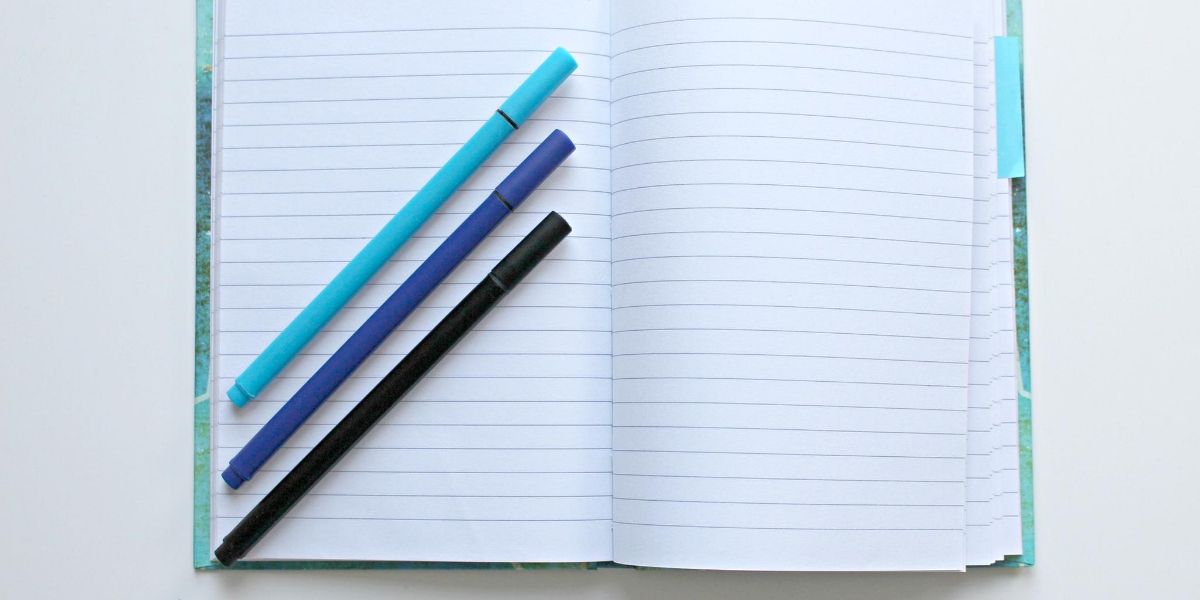 A blank notebook with pens