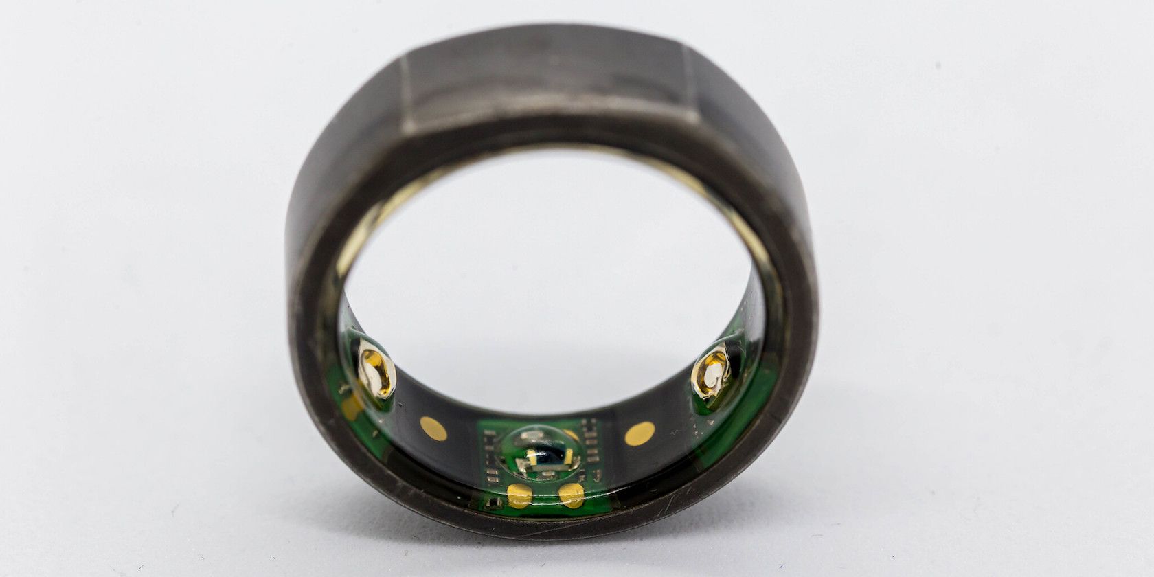 A close up shot of an Oura smart ring showing the electronic sensors inside