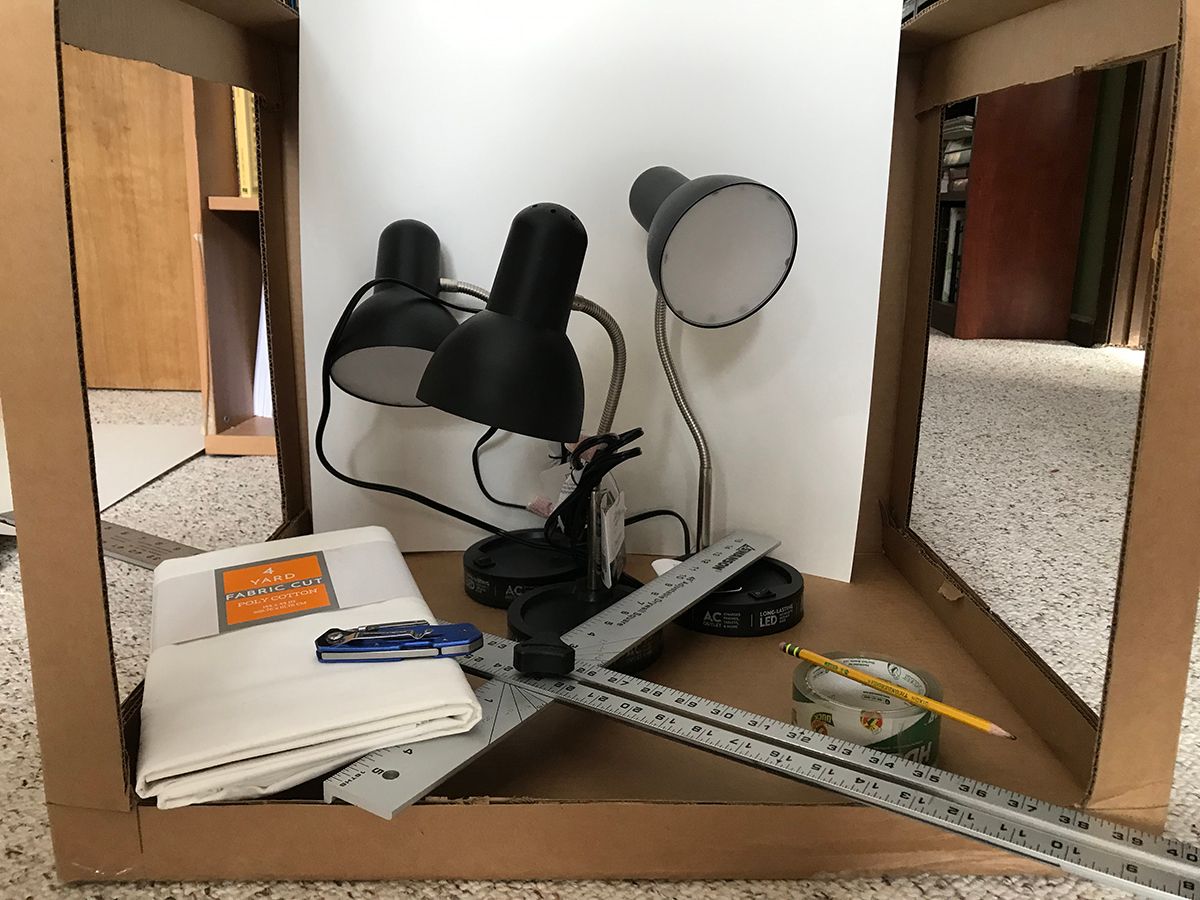 Supplies for Light Box Build: Box, Tape, Lamps, T Square, Knife, and Fabric
