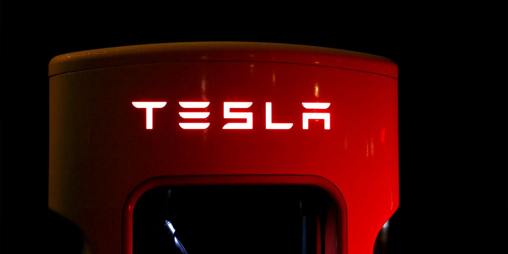a Tesla supercharger port lit by a car's brake lights