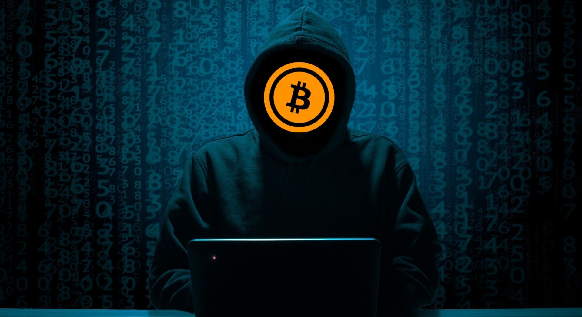 anonymous person by laptop with bitcoin hiding face