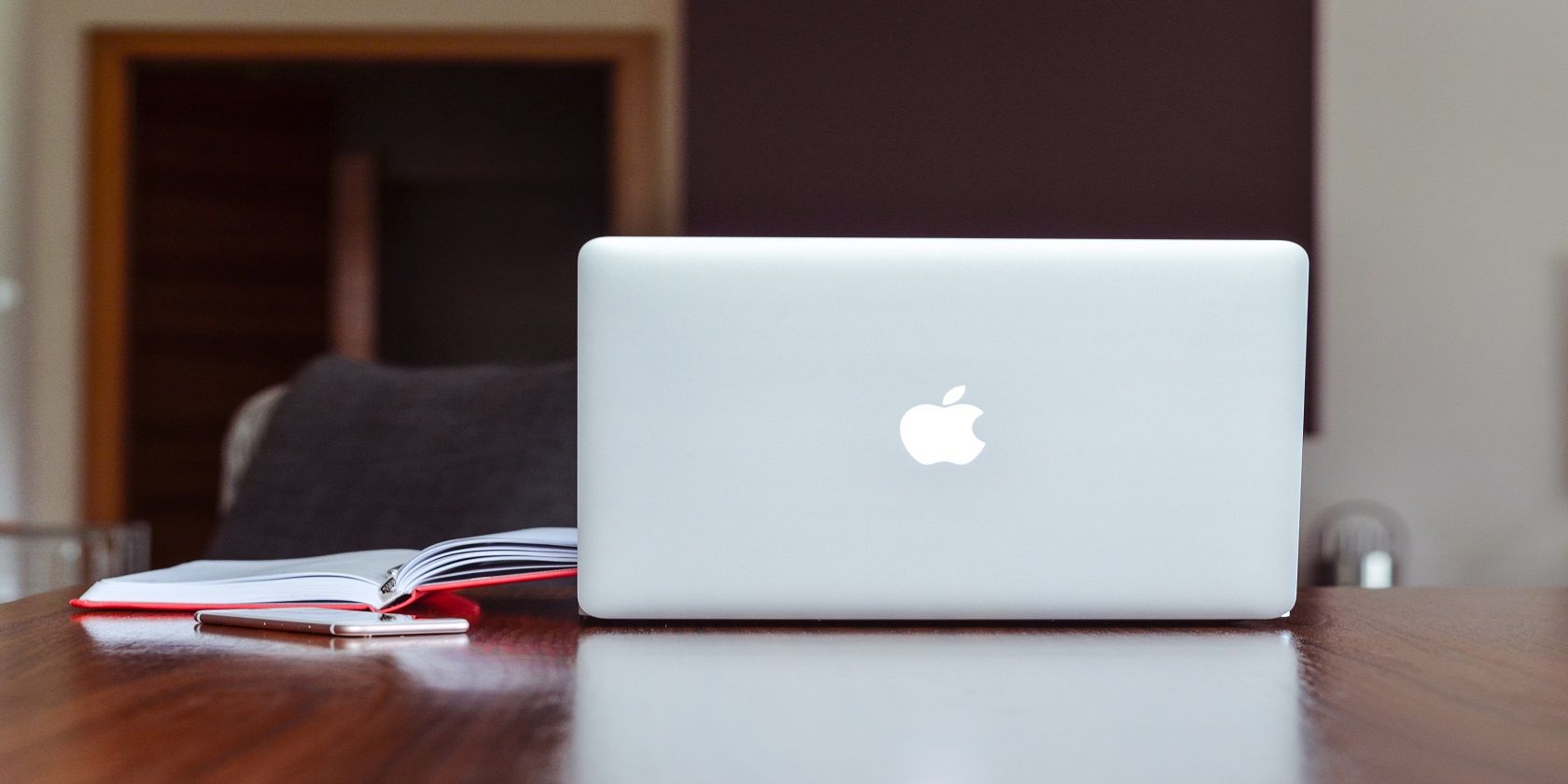 The silver reverse side of an apple laptop, sat on a desktop