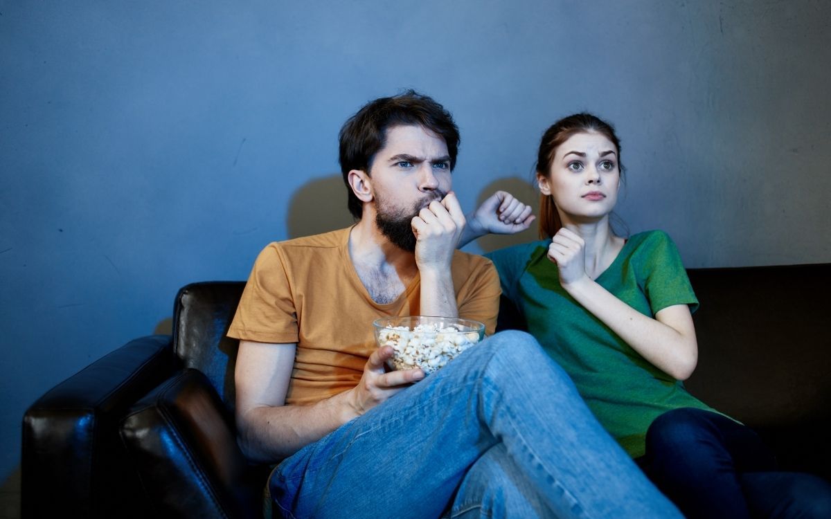 couple eating popcorn and watching tv