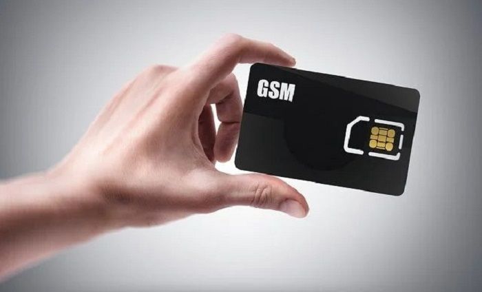 Man's hand holding black GSM SIM card