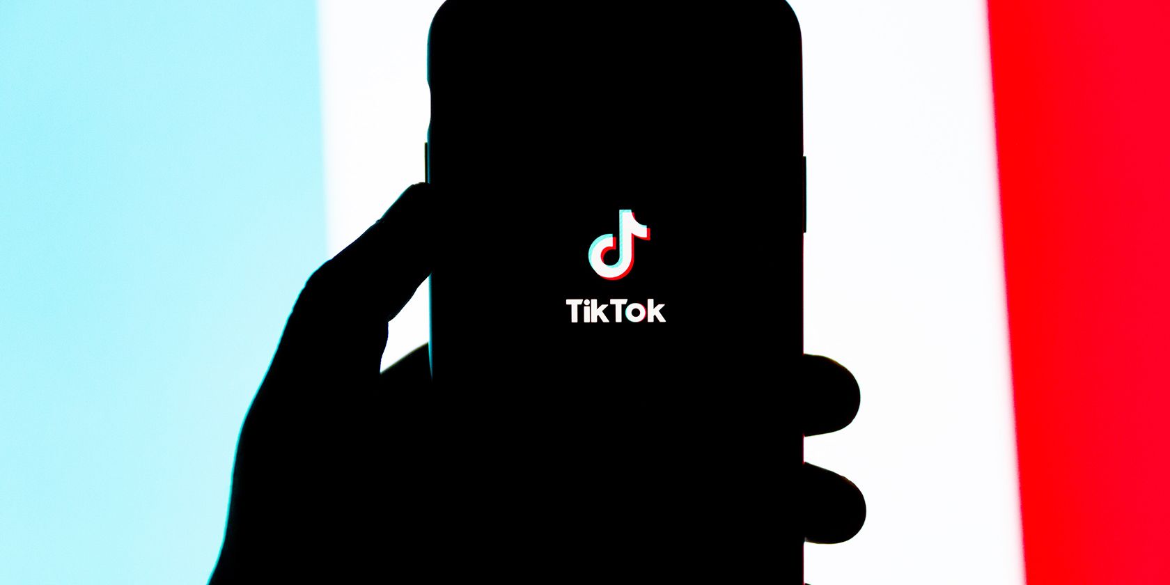 A person holding a phone with the TikTok logo.