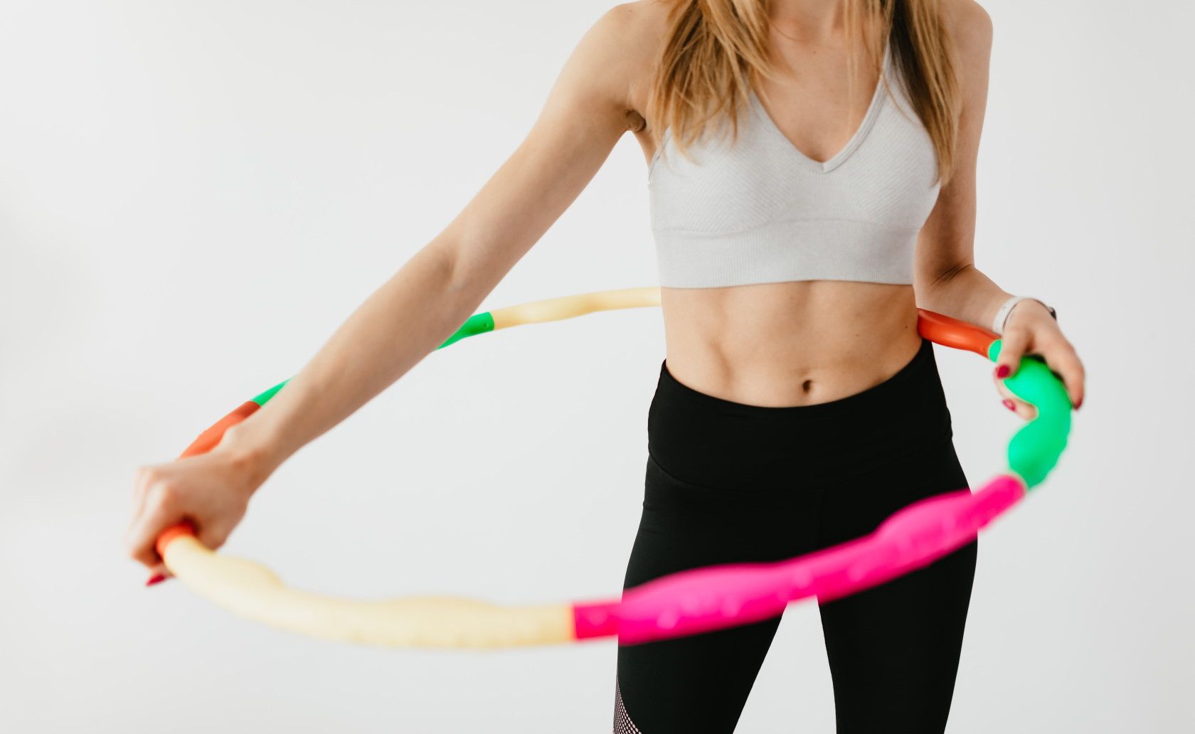 woman holding colorful exercise hula hoop