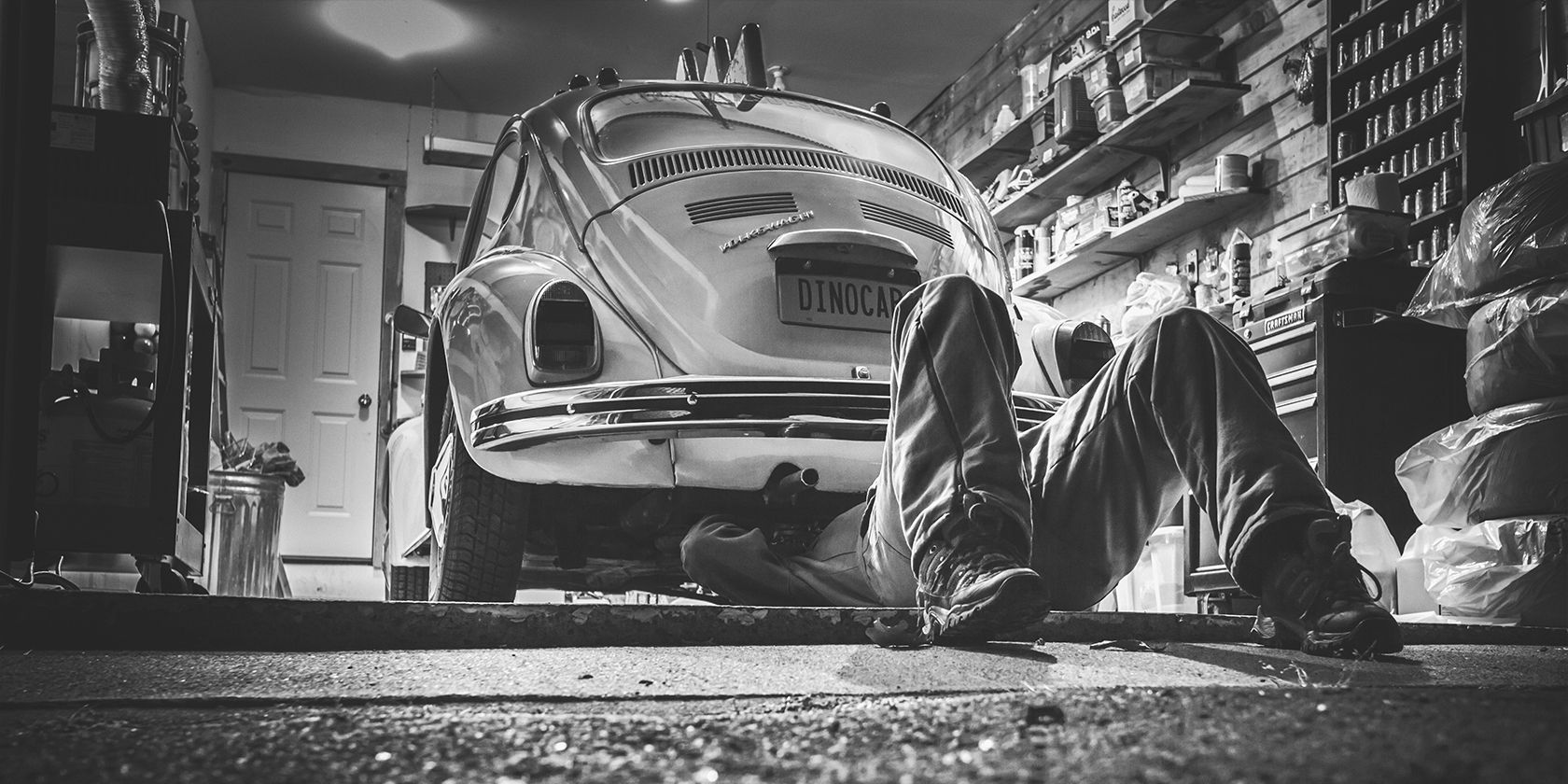 man repairing an old Volkswagen Beetle